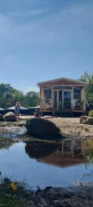 a house being constructed on a beach with a pool of water at Strandhuisje in Voorthuizen