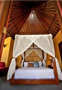 a bed with a canopy in a room at Balinese Villa in Berastagi in Berastagi