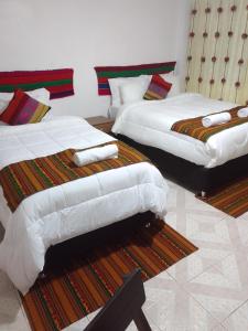 dwa łóżka siedzące w pokoju z w obiekcie Incas Town Inn w Cuzco