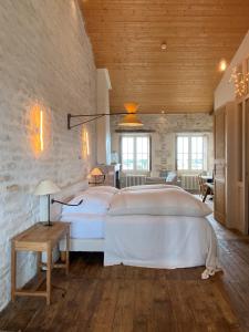 a bedroom with a large white bed in a room at Hôtel Le Sénéchal in Ars-en-Ré