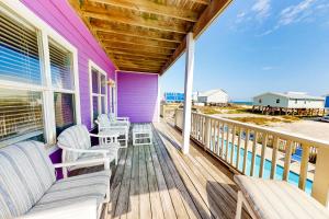 a porch with rocking chairs and a view of the ocean at Purple House East and West in Fort Morgan