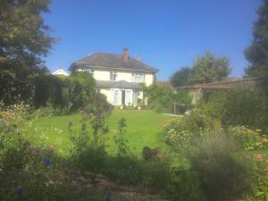 uma casa branca com um jardim em frente em Silver Lodge em Mildenhall