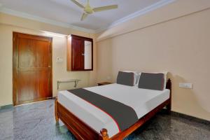 a bedroom with a bed and a ceiling fan at Family Castle Inn in Trivandrum