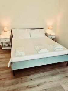 a bedroom with a bed with two lamps on two tables at La casa di Tommy in Monsummano