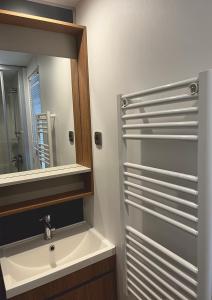 a bathroom with a sink and a mirror at Grand mobile-home 45M2 au calme et au bord de mer in Saint-Brevin-les-Pins