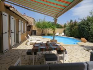 een patio met een tafel en stoelen en een zwembad bij Villa familiale piscine privée 6 personnes 6BJ21 in Saint-Estève