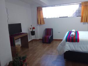 1 dormitorio con 1 cama, TV y ventana en Incas Town Inn, en Cusco