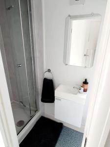 a white bathroom with a shower and a sink at Fabulous family house next to the beach in Nottage