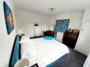a bedroom with a large bed with white sheets at Fabulous family house next to the beach in Nottage