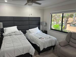 a bedroom with a bed and a chair and a window at SEA ECHO APPARTMENT MOTEL in Fort Lauderdale