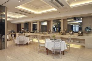 a restaurant with white tables and chairs and a counter at HOTEL ViA in Ansan
