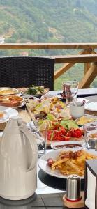 Kartal Yuvası Tatil Köyü في طرابزون: طاولة عليها أطباق من الطعام