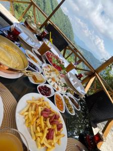 una mesa cubierta con platos de comida y patatas fritas en Kartal Yuvası Tatil Köyü en Trebisonda