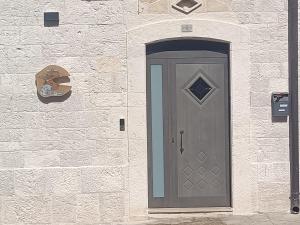 une porte grise sur le côté d'un mur de briques dans l'établissement Il rifugio del folletto, à Santeramo in Colle