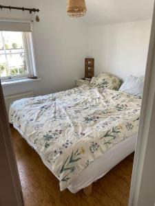 un letto con piumone floreale in una camera da letto di Cosy house near the beach in Torekov a Torekov
