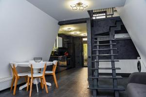 a dining room with a table and chairs and a spiral staircase at Anna Chalet in Breaza de Sus