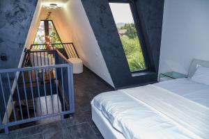 a bedroom with a bed and a staircase with windows at Anna Chalet in Breaza de Sus +23 photos