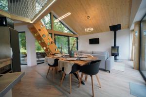 a kitchen and dining room with a wooden table and chairs at Szőcs-birtok Apartments in Izvoare