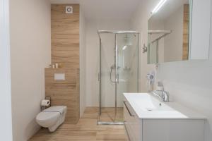 y baño con ducha, aseo y lavamanos. en Horyzont Apartamenty- Bałtycka 7AB- ŚNIADANIA en Kołobrzeg