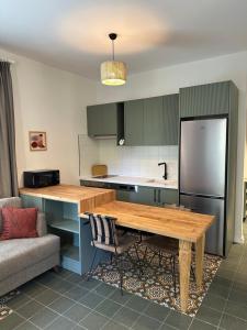 a kitchen with a wooden table and a refrigerator at Esmahan Forest and Pool by Zehra Suites in Marmaris