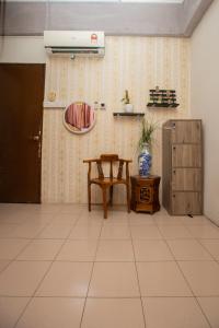 een kamer met een tafel, een stoel en een muur bij Escape Backpackers KK in Kota Kinabalu