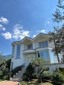 a large white house with stairs in front of it at Hilltop Villa in Tirana