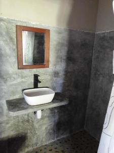 a bathroom with a sink and a mirror at Villa Métisse in Nosy Be