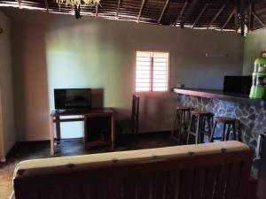 a bar in a room with a counter and stools at Villa Métisse in Nosy Be