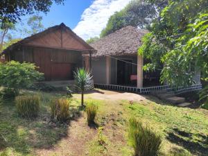 a house with a grass roof and a yard at Villa Métisse in Nosy Be