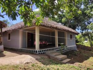 una pequeña casa blanca con techo de paja en Villa Métisse, en Nosy Be