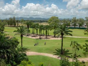 a golf course with palm trees and people riding bikes at Comfortable apartments in Laguna Skypark in Phuket