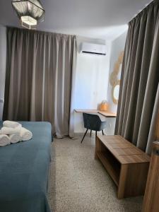a bedroom with a bed and a desk with a chair at Adamandri Lodge - Prime Location in Ayia Napa