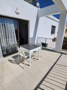 un tavolo e due sedie seduti su un patio di Adamandri Lodge - Prime Location a Ayia Napa