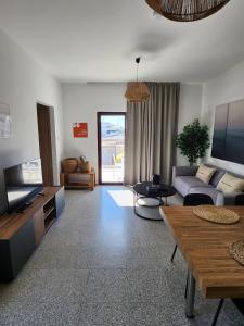 a living room with a couch and a tv at Adamandri Lodge - Prime Location in Ayia Napa