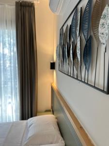 Un dormitorio con una cama y una pared con plumas. en Esmahan Forest and Pool by Zehra Suites, en Marmaris
