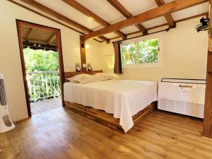 a bedroom with a bed and a large window at Kalinao - Bungalow chic en nature in Les Abymes