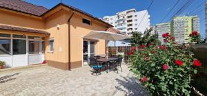 a patio of a house with a table and an umbrella at Casa Anton Buzău in Buzău