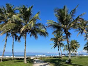 una fila de palmeras en la playa en APTO RIVIERA 2 DORMS COM AR A 180 m DA PRAIA ! APROVEITE AS BAIXAS TARIFAS DE MAIO ! CONSULTE !, en Riviera de São Lourenço