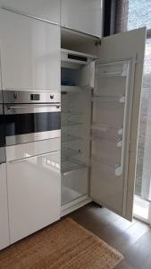 een lege keuken met witte kasten en een koelkast bij Brussel-center lux apartment in Brussel