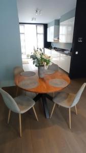 a wooden table with chairs and a vase of flowers on it at Brussel-center lux apartment in Brussels