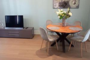 een tafel met stoelen en een vaas met bloemen erop bij Brussel-center lux apartment in Brussel