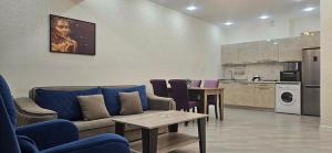 sala de estar con sofá, mesa y cocina en Park Azure Comfortable Apartment, en Baku