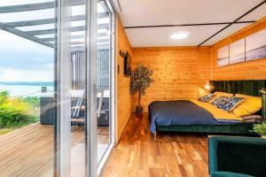 1 dormitorio con 1 cama y balcón en Tinyhouse with view to Balaton - Liliput Houses en Balatonakarattya