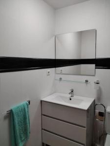 Baño blanco con lavabo y espejo en Ca'Xexu en Telde