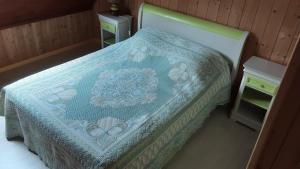 ein Schlafzimmer mit einem Bett mit einer blauen Decke darauf in der Unterkunft Ty Eflenn in Locunolé