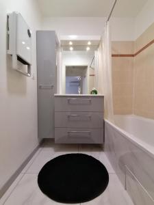 baño con lavabo y alfombra negra en Les Portes du Soleil, en Grabels