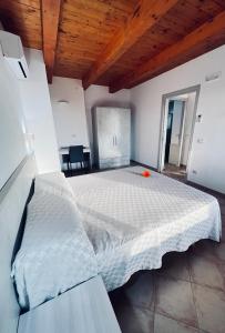 um quarto com uma grande cama branca e um tecto de madeira em B&B Casale Pietrantica Tropea em Ciaramiti