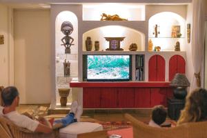 a group of people sitting in chairs watching a tv at Tree Lodge Mauritius Villa in Argy