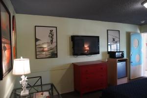 a living room with a tv and a red dresser at Huntington Surf Inn in Huntington Beach