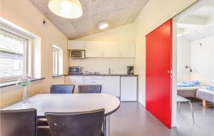 kuchnia ze stołem i krzesłami oraz czerwonymi drzwiami w obiekcie 2 Bedroom Beautiful Home In Spjald w mieście Spjald